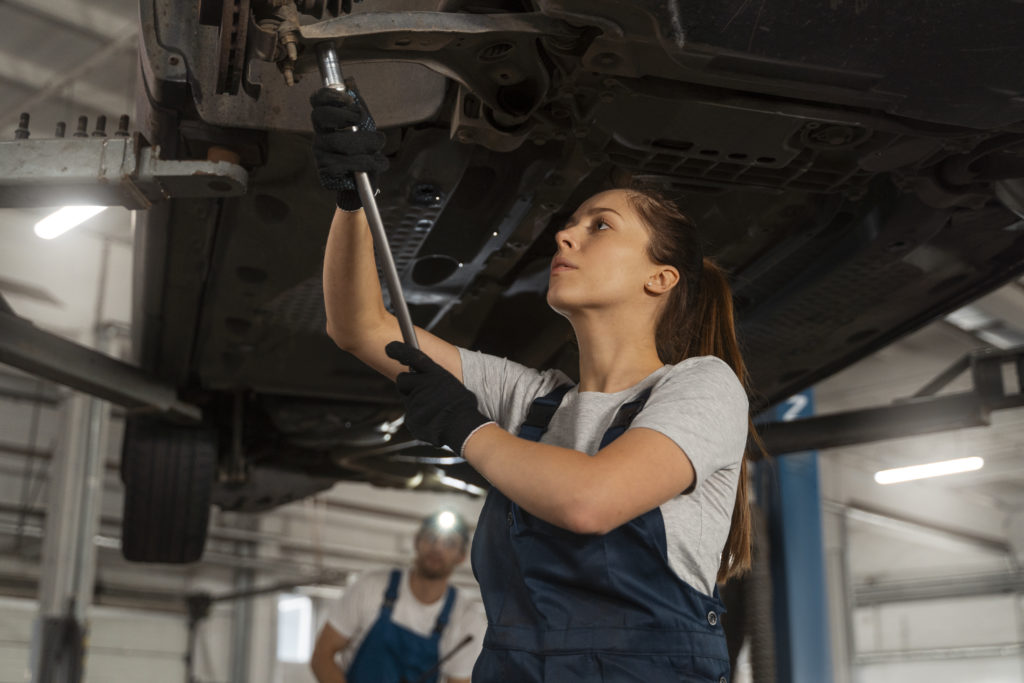 mujer reparando amortiguadores de un auto