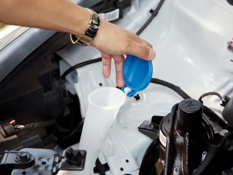 persona-pone-agua-al-auto