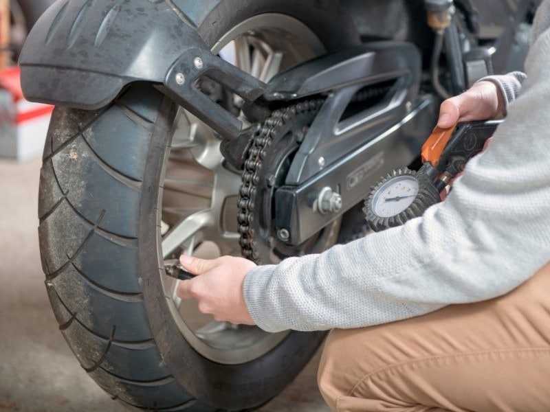 persona-controla-presion-rueda-de-moto